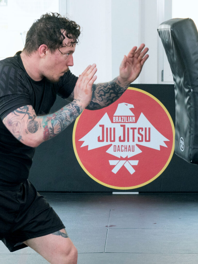 Mann trainiert Krav Maga zur Selbstverteidigung und zum Stressabbau nach der Arbeit.