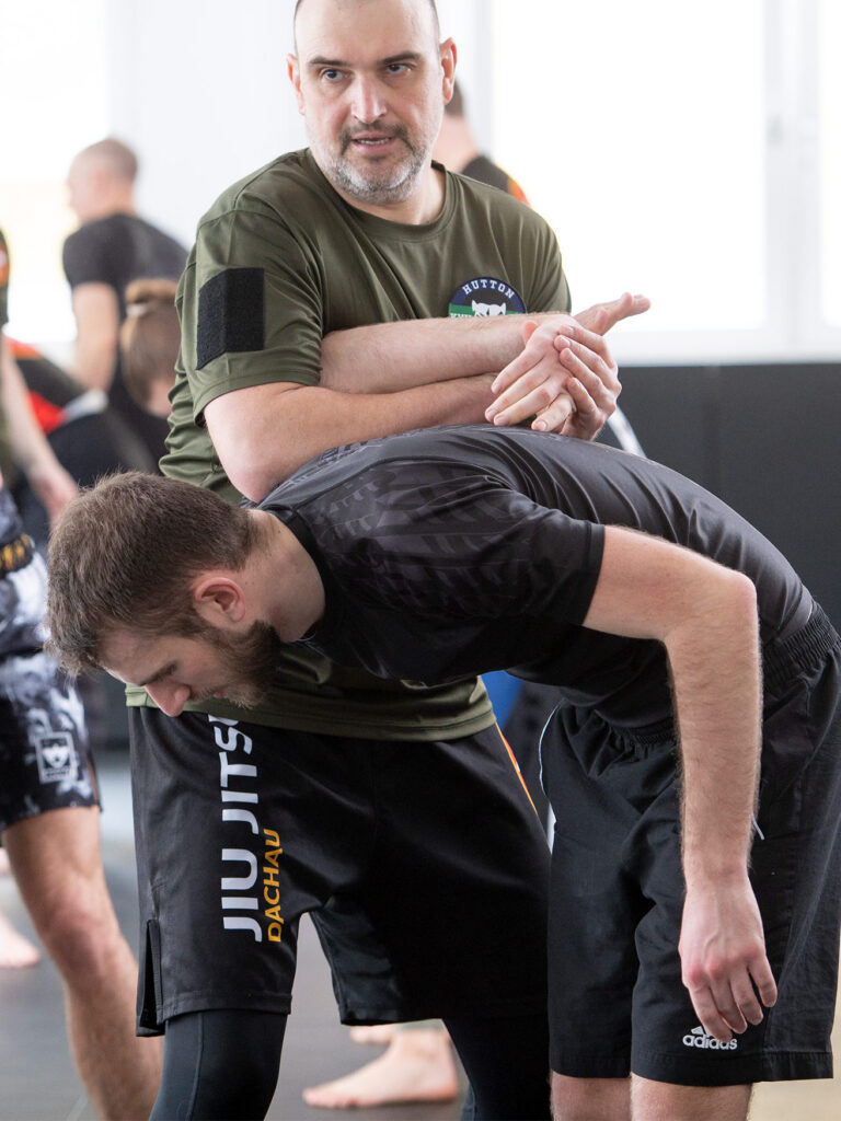 Trainer zeigt einem Teilnehmer eine Krav Maga Selbstverteidigungstechnik für mehr Sicherheit im Alltag.